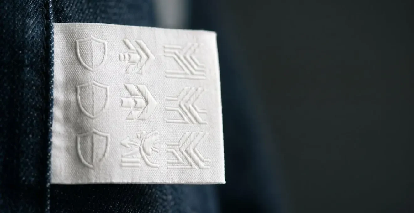 Gros plan sur une étiquette de certification textile moto avec pictogrammes de sécurité